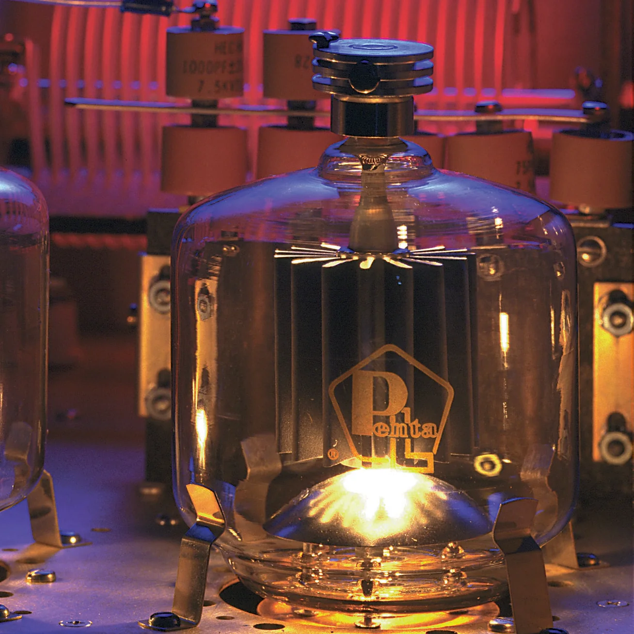 Glowing Penta vacuum tube mounted inside electronic equipment.
